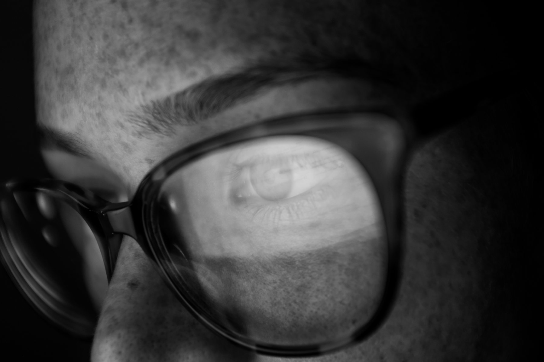 Close-up black and white portrait reflected in glasses